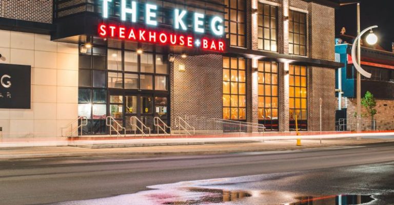 Steakhouses - Roadway with puddle reflecting signboard of contemporary building