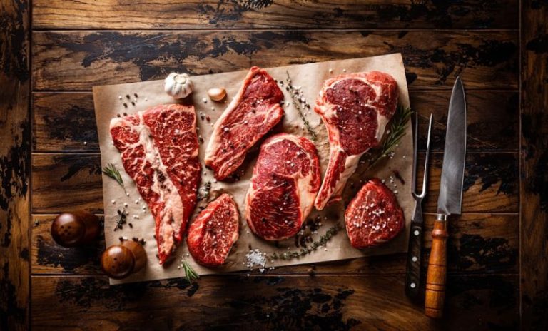 Steakhouses - raw meat on a cutting board next to a knife